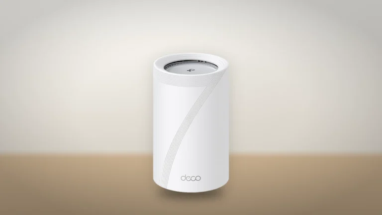 Front view of a white Deco BE65 Pro node with its vented top and deco logo, standing on a light wooden desk
